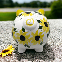 Hand painted personalized piggy bank with yellow sunflowers and dark green leaves.