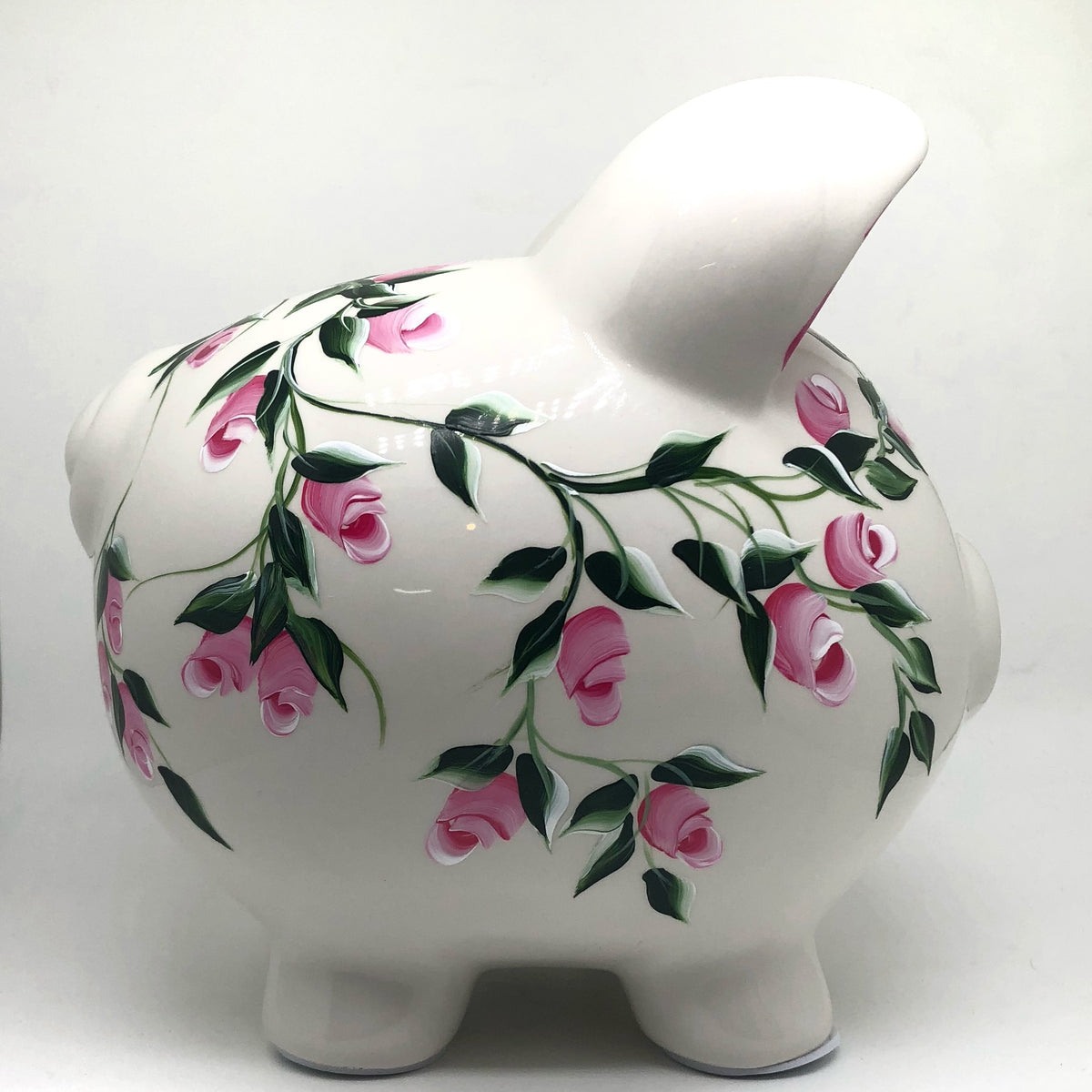 hand painted personalized piggy bank with pink rosebuds and green leaves and vines. A lovely new baby gift.