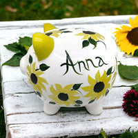 Hand painted personalized piggy bank with yellow sunflowers and dark green leaves.