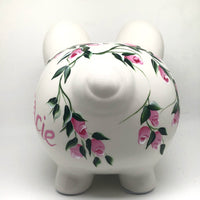 hand painted personalized piggy bank with pink rosebuds and green leaves and vines. A lovely new baby gift.